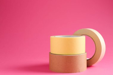 Pembe arka planda farklı maskeleme bantlarının ruloları, metin için boşluk