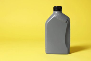 One grey plastic canister on yellow background, space for text