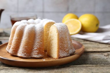 Tahta masaya pudra şekerli lezzetli limonlu pasta, yakın plan.