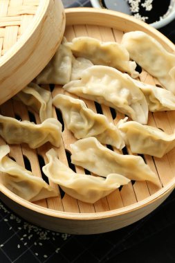 Bambu buharlı tencerede kaynamış gyoza (hamur tatlısı), yakın plan.