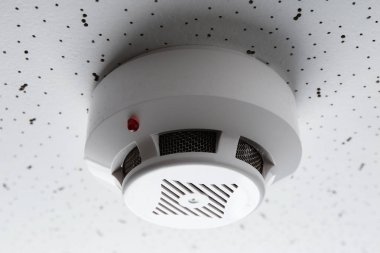 Işık desenli arka planda duman dedektörü, yakın plan. Alarm sistemi