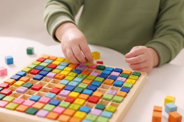 Motor beceri geliştirme. Küçük çocuk Times masa tepsisiyle içeride oynuyor, yakın plan.