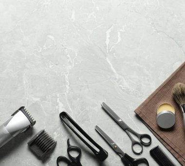 Many different barber's tools on light grey table, flat lay. Space for text