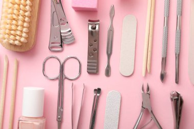 Pembe arka planda farklı manikür araçları, düz yatış
