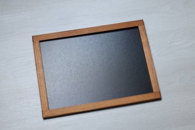 Hafif ahşap zemin üzerinde boş küçük karatahta, üst görünüm