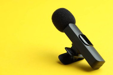 Sarı arka planda Lavalier mikrofonu, yakın plan. Metin için boşluk