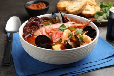 Gri desenli masada servis edilen lezzetli deniz ürünleri çorbası, yakın plan.