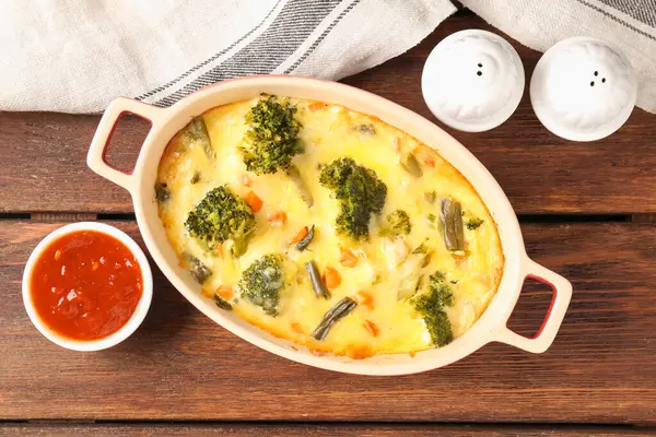 Lezzetli sebze güveci, ahşap masada sos ve baharatlar, düz uzanma