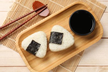 Pirinç topları (onigiri), soya sosu ve ahşap masa üzerindeki çubuklar, düz yatak. Geleneksel Japon yemeği