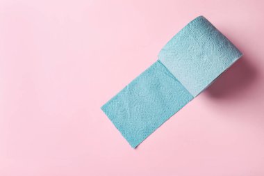 Açık pembe arka planda mavi tuvalet kağıdı rulo, üst manzara. Metin için boşluk