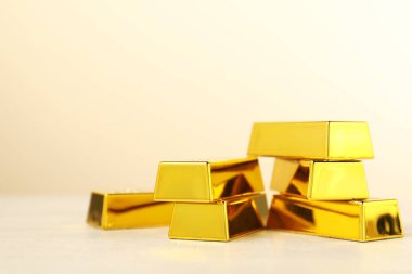 Bej arka planda altın külçeleri var, yakın plan. Metin için boşluk