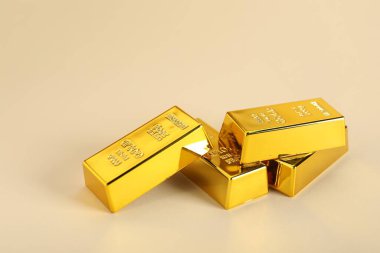 Bej arkaplanda parlak altın çubuklar, yakın plan