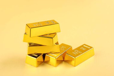 Bej arkaplanda parlak altın çubuklar, yakın plan