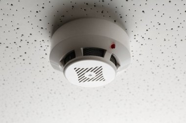 Işık desenli arka planda duman dedektörü, yakın plan. Alarm sistemi