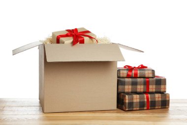 Beyaz arkaplana karşı ahşap masanın üzerinde hediye kutuları olan paket
