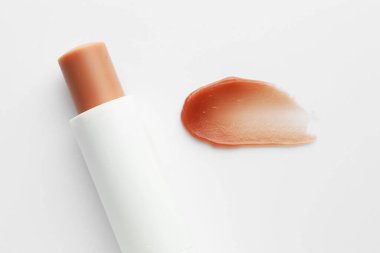 Dudak kremi ve örnek beyaz arka planda, üst görünümde.