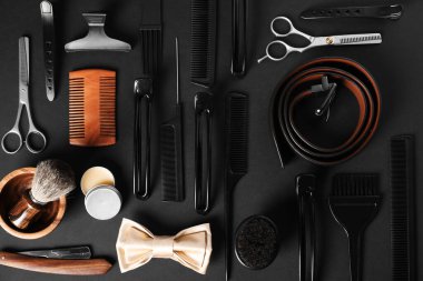 Siyah masanın üzerinde bir sürü farklı berber aleti vardı.