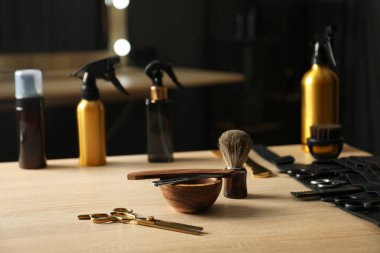 Berber dükkanında, açık ahşap masada birçok farklı berber aletleri var.