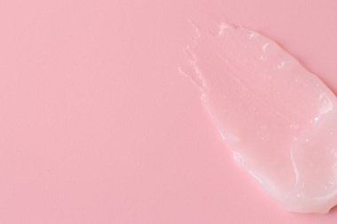 Pembe arka planda nemlendirici dudak kremi, üst manzara. Metin için boşluk