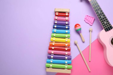 Renk arkaplanında farklı müzik aletleri olan düz bir kompozisyon. Metin için boşluk