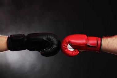 Boks eldivenli adamlar karanlık arka planda dumanla savaşıyor.