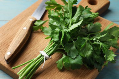 Taze maydanoz, bıçak ve tahta kesme tahtası mavi ahşap masa, yakın plan