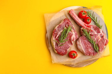 Çiğ sığır eti, biberiye ve domates parçaları sarı masada, üst tarafta. Metin için boşluk