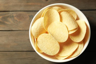 Tahta masada, tabakta patates cipsi, üst manzara. Metin için boşluk