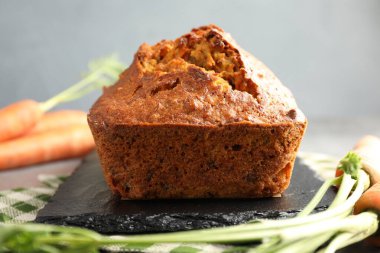 Gri masada lezzetli havuçlu kek ve sebzeler, yakın plan.