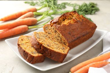 Açık gri masada fındıklı ve sebzeli ev yapımı havuçlu kek, yakın plan.