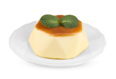 Karamel soslu lezzetli puding ve beyaz üzerine izole edilmiş nane.