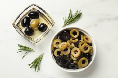 Farklı lezzetlerde marine edilmiş zeytin halkaları, tüm olanlar ve biberiye ışık masasında, düz yatıyordu.