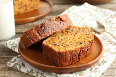 Ev yapımı havuçlu kek, fındıklı ve kaşıklı, ahşap masa, yakın plan.