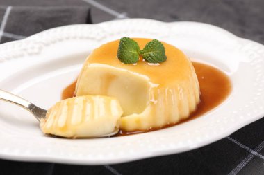Karamel soslu lezzetli puding ve nane şekeri, yakın plan.