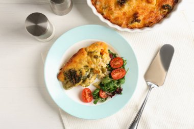 Lezzetli sebze güveci ve beyaz ahşap masada salata.