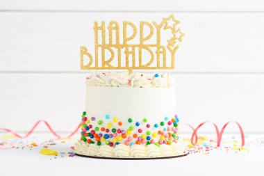 Lezzetli bento keki, üzerine renkli süsler serpiştirilmiş, beyaz masa, yakın plan.