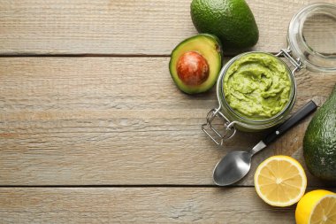 Lezzetli avokado sosu cam kavanoza, meyveler ahşap masaya, düz yere. Metin için boşluk