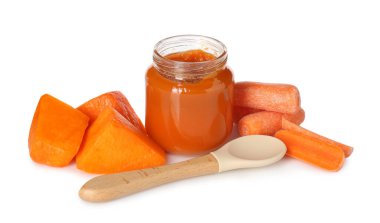 Bebek maması. Kavanozda lezzetli püre, beyaz arka planda kaşık ve malzemeler