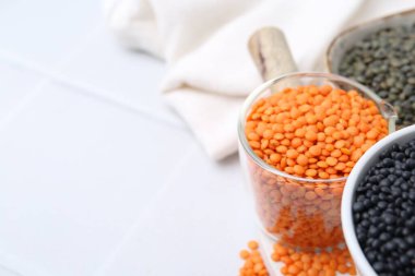 Beyaz masada farklı türde mercimek, yakın plan. Metin için boşluk