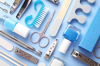 Açık mavi zemin üzerinde farklı manikür araçları kümesi, düz yatıyordu