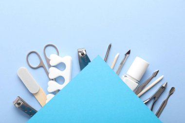 Açık mavi zemin üzerinde farklı manikür araçları seti, düz yatıyordu. Metin için boşluk