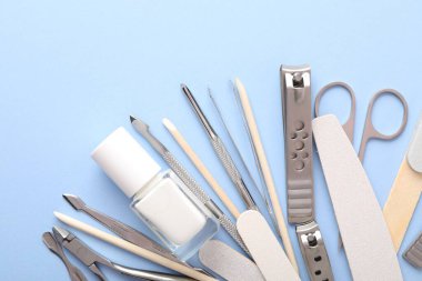 Açık mavi zemin üzerinde farklı manikür araçları kümesi, düz yatıyordu