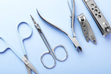 Açık mavi zemin üzerinde farklı manikür araçları kümesi, düz yatıyordu