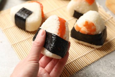 Hafif masada nefis onigiri (Japon pirinç topu) olan kadın, yakın plan.