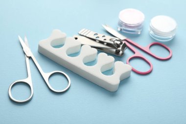 Açık mavi arkaplanda farklı manikür araçları seti, yakın plan