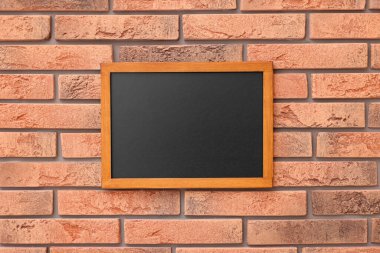 Tuğla duvarda boş küçük bir tahta.