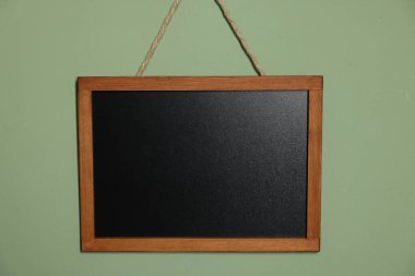 Açık yeşil duvarda boş bir karatahta