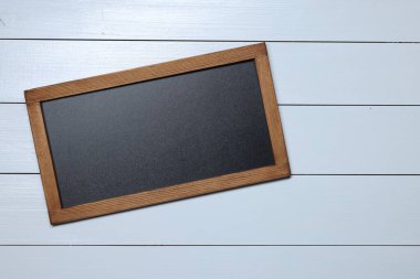 Beyaz ahşap zemin üzerinde boş küçük karatahta, üst görünüm