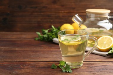 Tahta masada limon dilimleri olan sağlıklı maydanoz çayı, mesaj için yer. Detoks içeceği