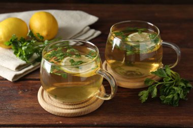 Tahta masada limon dilimleri olan sağlıklı maydanoz çayı, yakın plan. Detoks içeceği